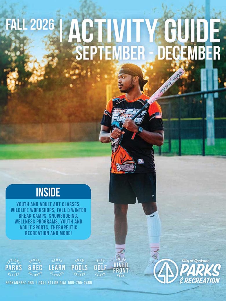 Image: A person in and orange and black jersey on a sports field holding a baseball, ready to play ball. 